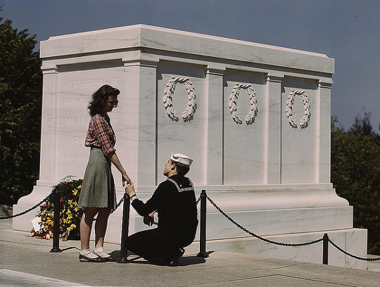 World War Two Fashion girl wearing a pencil skirt as soldier kneels before her