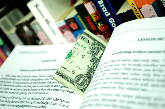 Thrift Store Finds Money a dollar bill caught between the pages of a course in miracles book